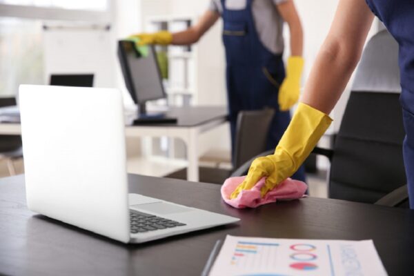Janitor wiping table in office